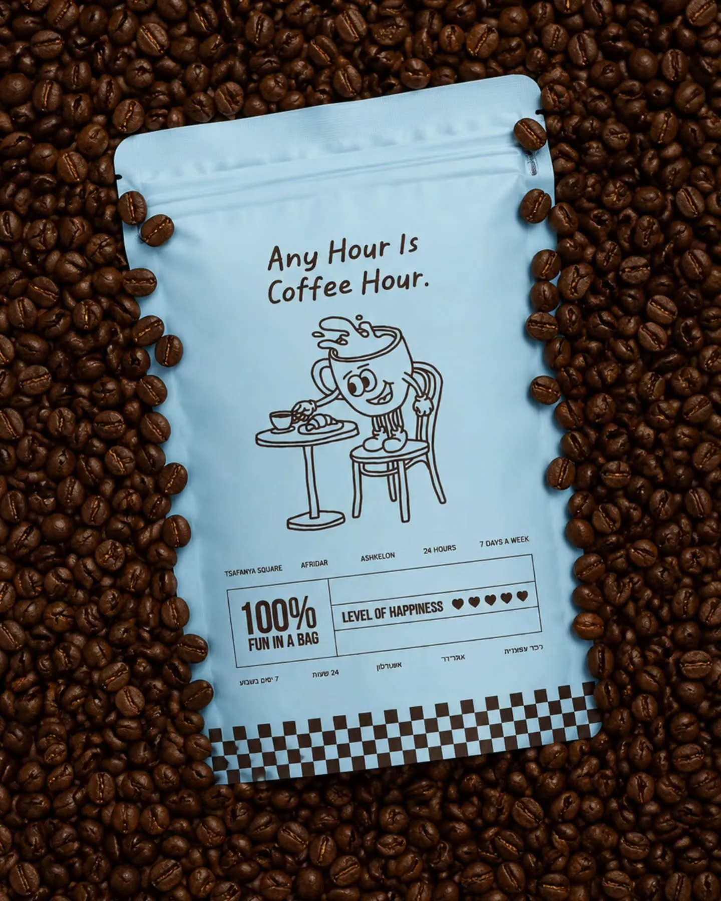 שקית פולי קפה תכלת של קופי קלאב על מצע פולים — Any Hour Is Coffee Hour